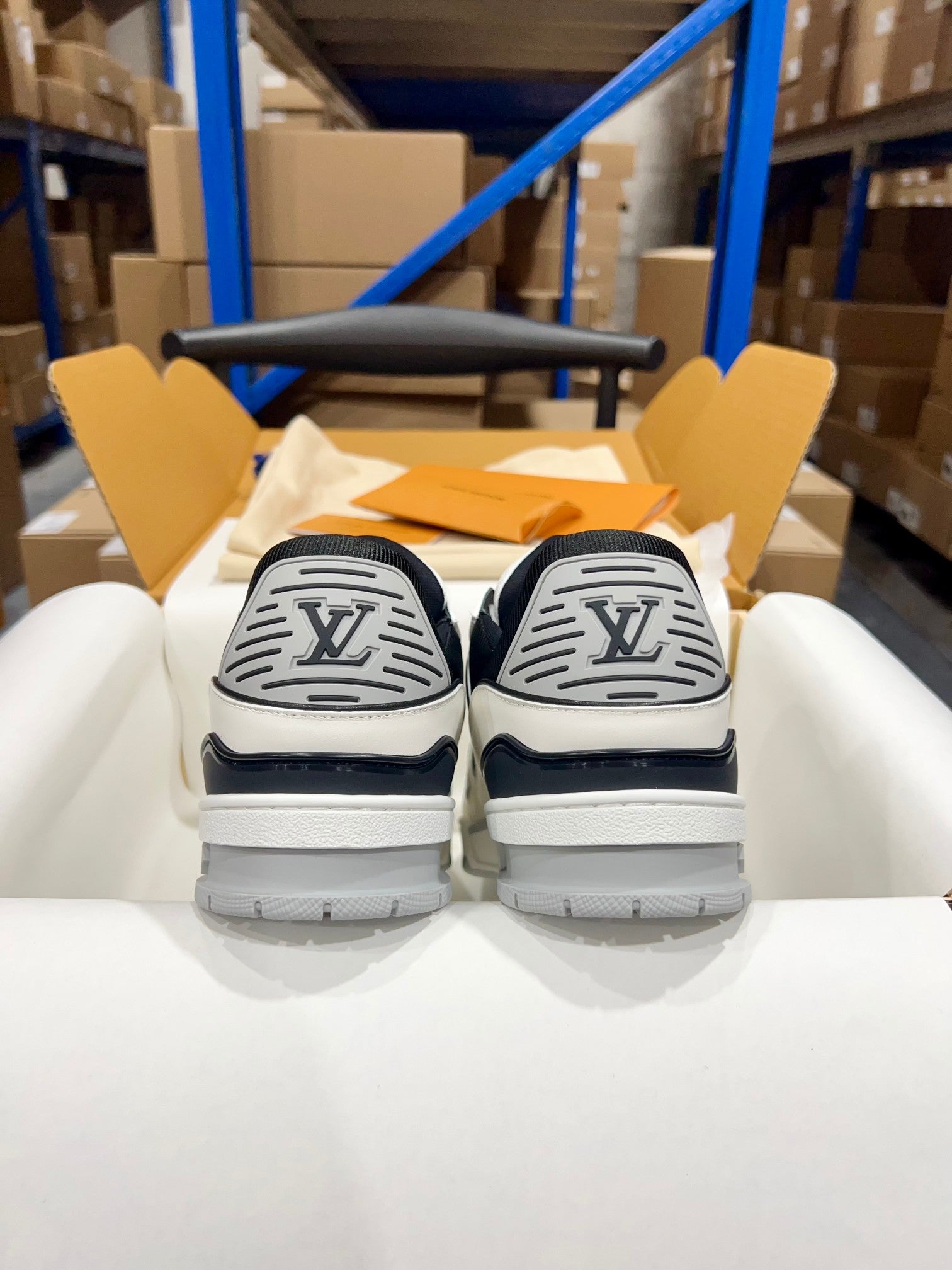 Louis Vuitton trainer shoes with navy heel and embossed LV logo on the back