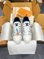Louis Vuitton trainer sneakers, white leather with navy heel and embroidered blue “LV” marks.