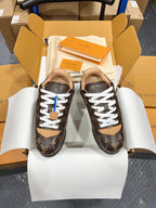 Unisex Louis Vuitton monogram sneakers with white laces and tan heel detail