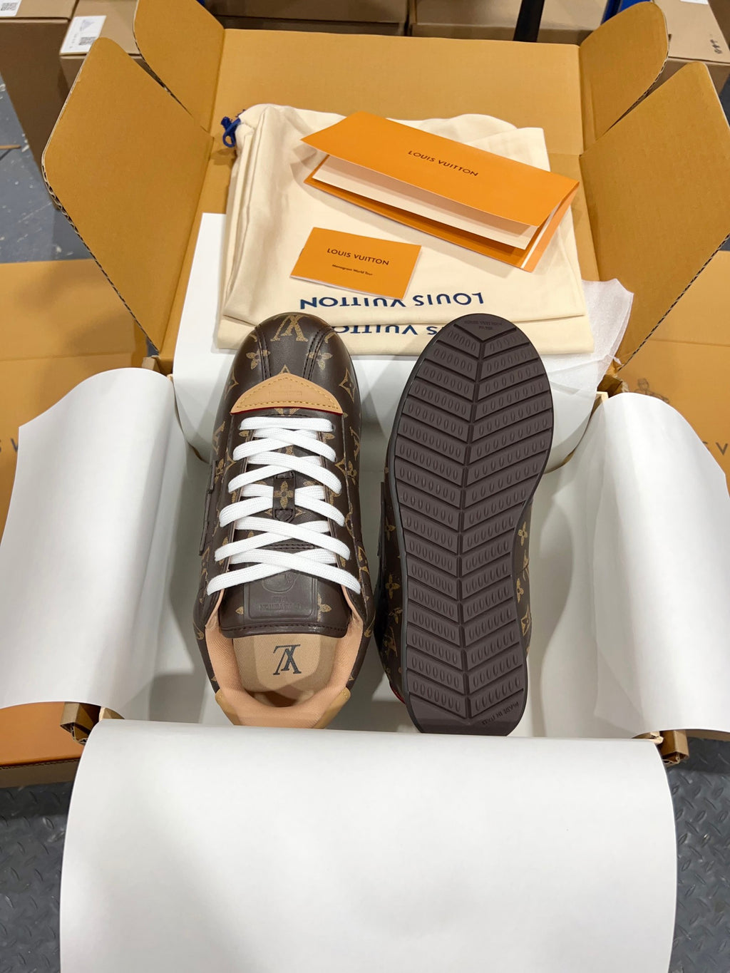 Unisex monogram sneakers shown with treaded outsole, dark brown and white laces