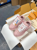 Louis Vuitton pink low-top sneakers with white laces, side view on a white shoebox insert.