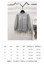 Gray sweatshirt front view with size chart table