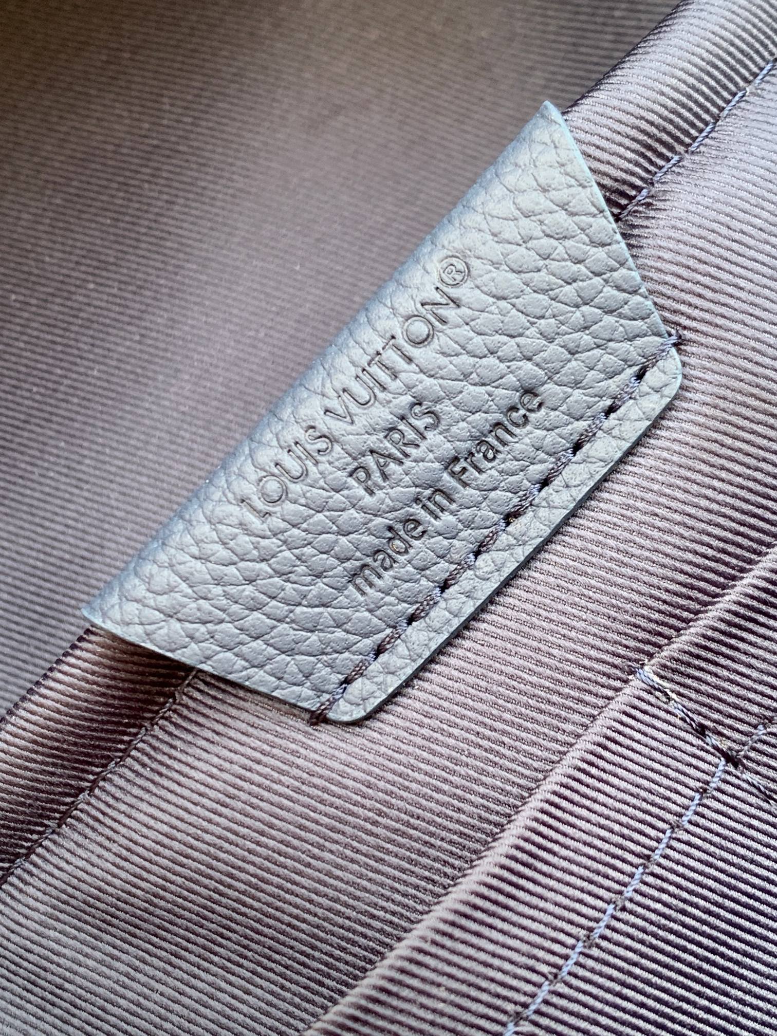 Louis Vuitton mini backpack leather label with embossed text and stitch edges