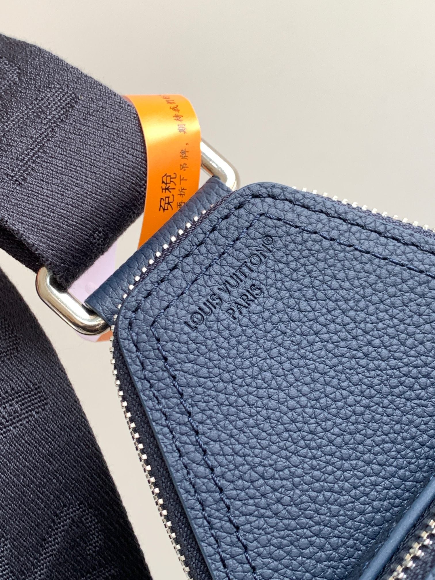 Louis Vuitton blue textured leather bag with zipper top and embossed logo patch