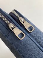 Louis Vuitton blue bag detail showing dual zipper pulls and metal slider hardware