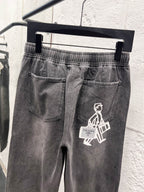 Gray denim pants with front patch pocket and white graphic emblem