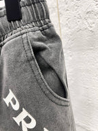 Gray denim pants waistband detail with drawstring and PRADA print
