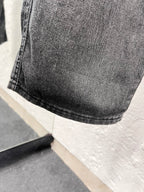 Dark gray denim fabric with curved hem and stitched cuff detail