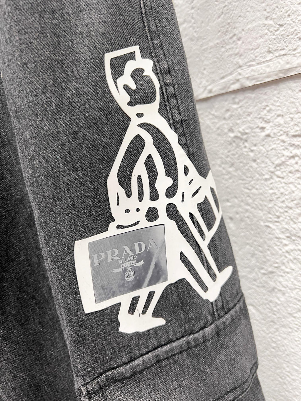 Dark gray denim cargo pants with white graphic patch on side pocket
