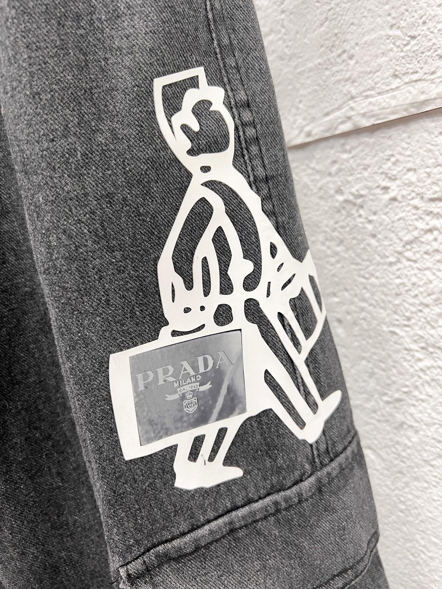 Dark gray denim cargo pants with white graphic patch on side pocket