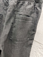 Dark gray denim cargo pocket with stitched details on front leg