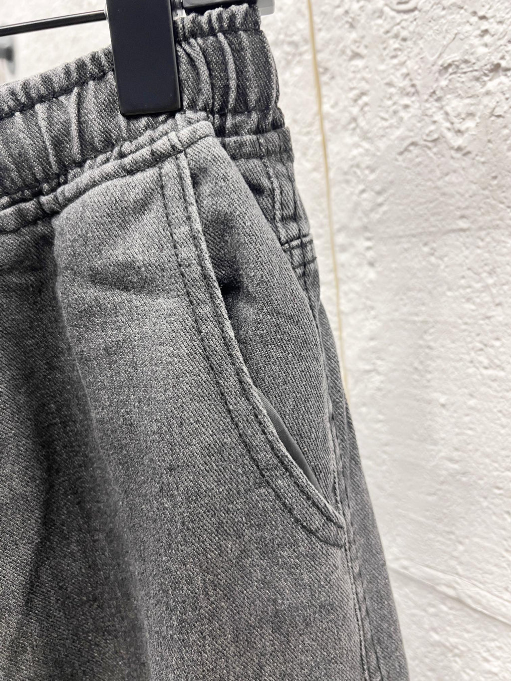 Dark gray denim waistband with elastic and seam detail on cargo pants