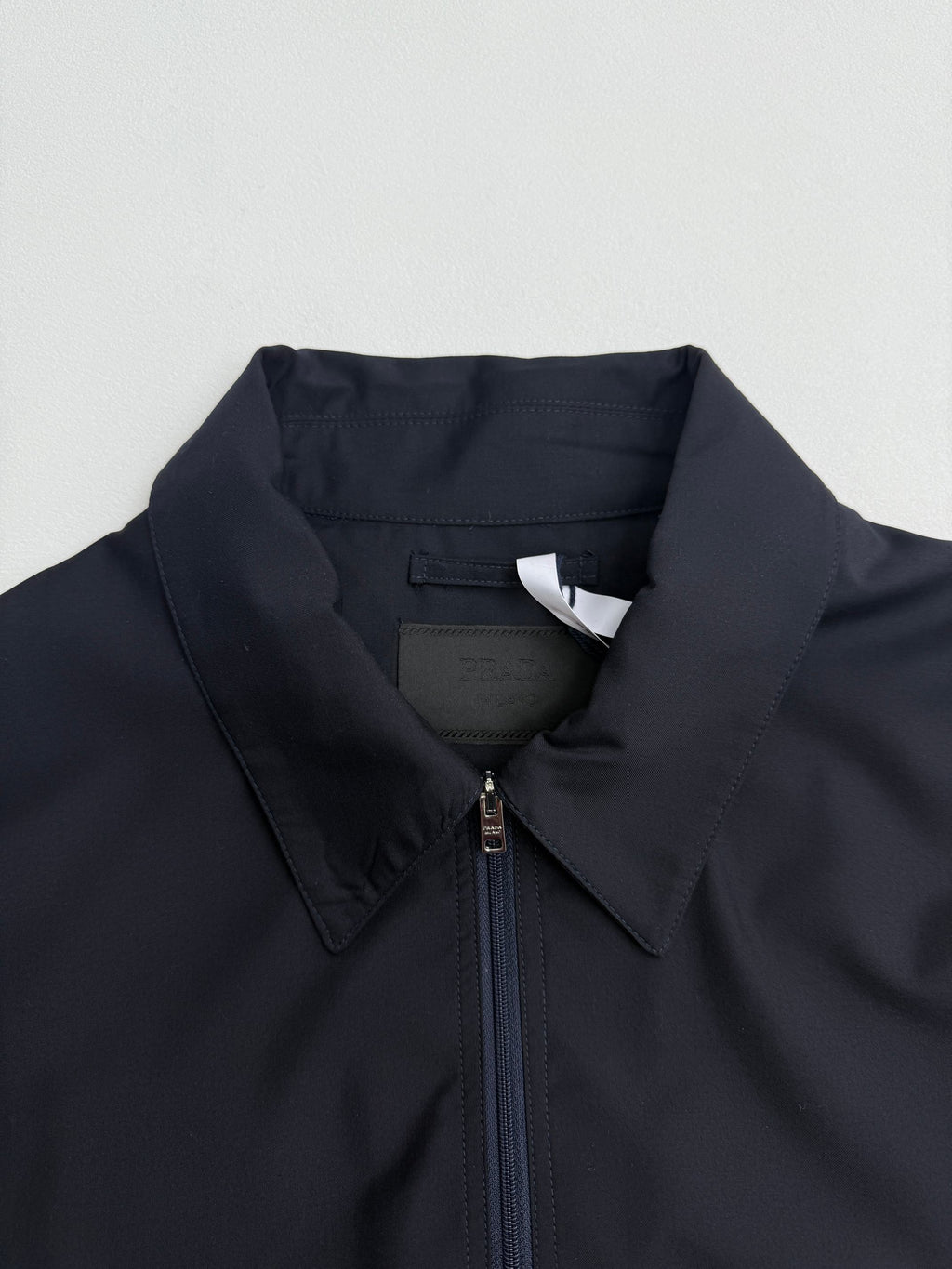 Prada long jacket dark navy with stand collar and centered zipper placket close-up