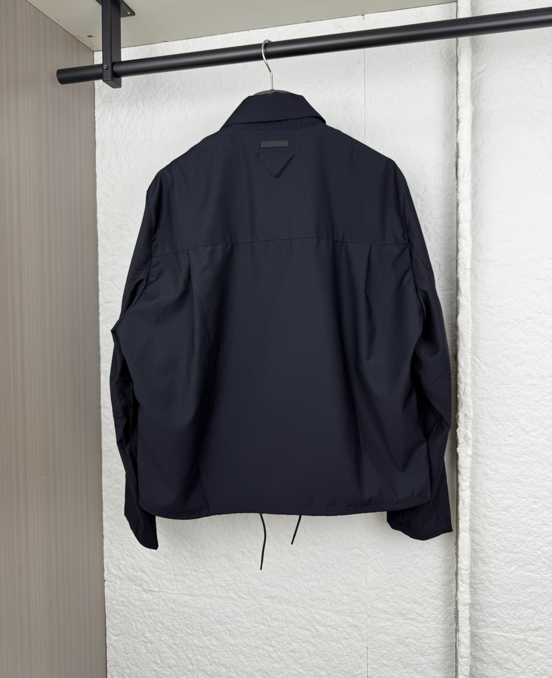 Prada long jacket back view in dark navy with stand collar and drawstring at hem