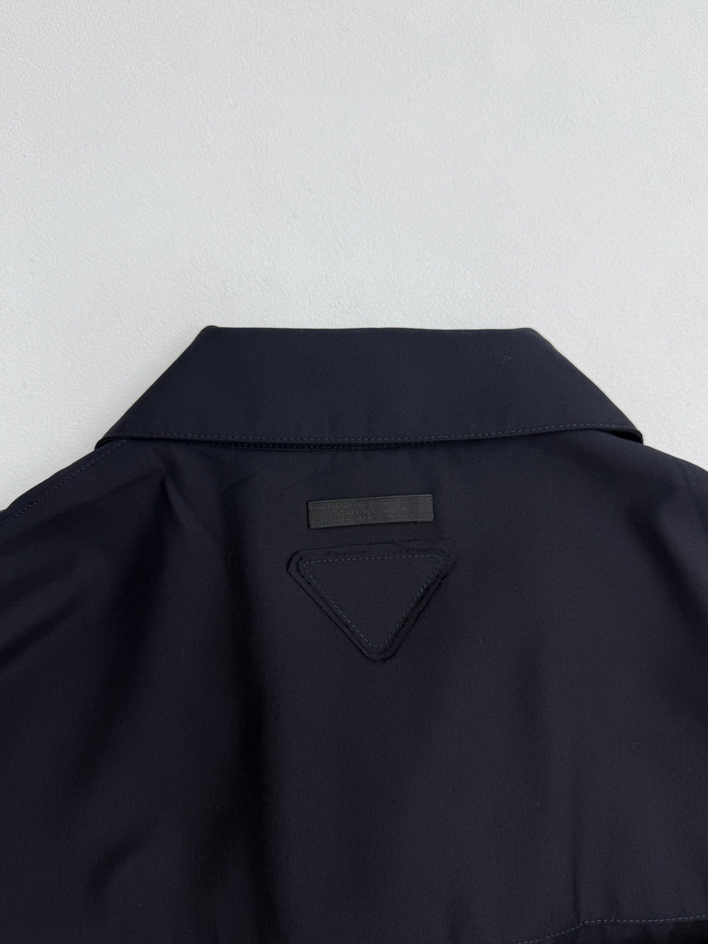 Prada long jacket dark navy back yoke with small triangular logo patch