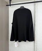 Black long-sleeve shirt, plain back view with relaxed fit and draped hem