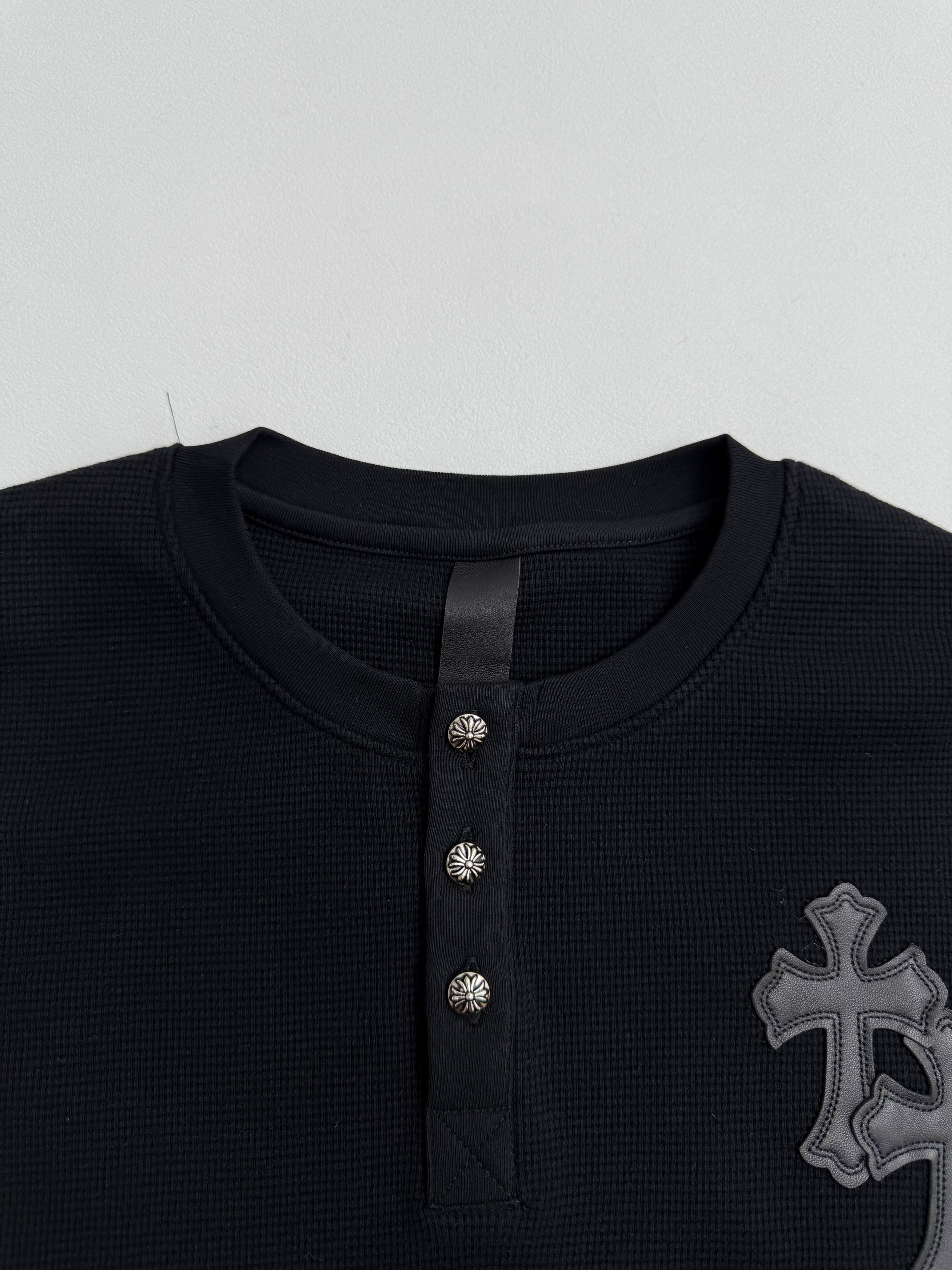 Black long-sleeve henley neckline with three button placket and textured panel detail