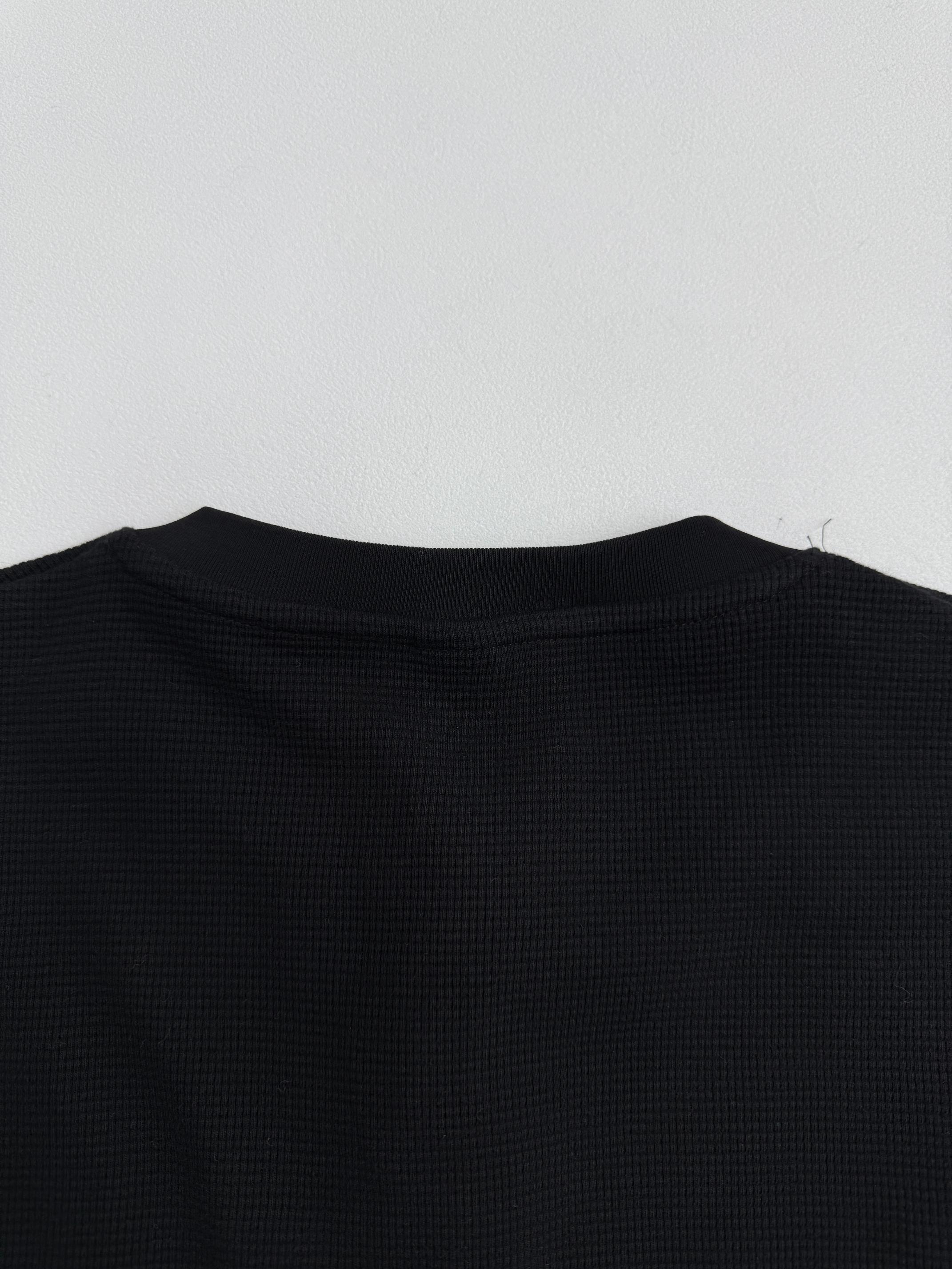 Black long-sleeve shirt back with crew neckline and textured fabric surface