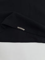 Black long-sleeve shirt cuff label detail on the sleeve hem