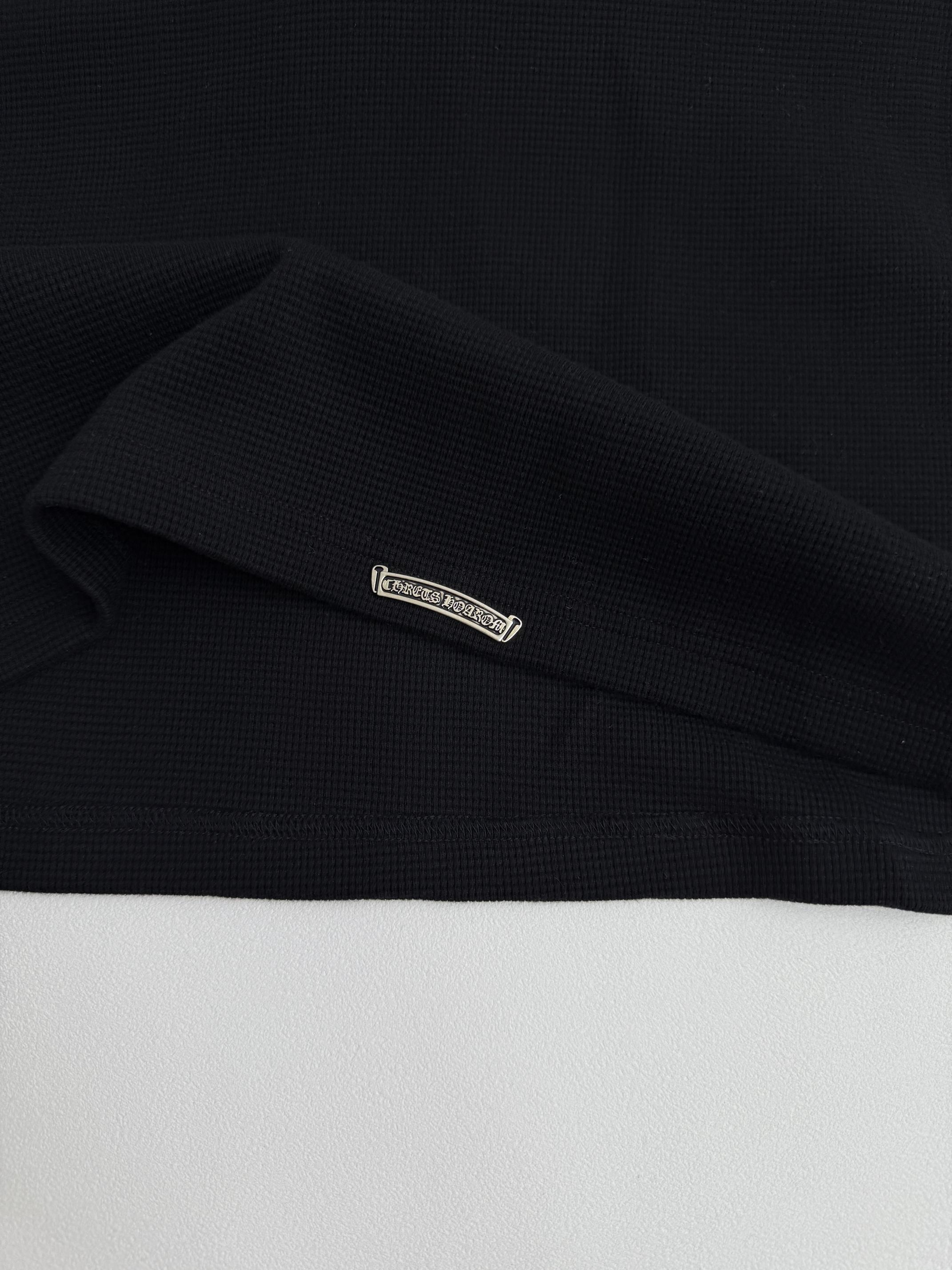 Black long-sleeve shirt cuff label detail on the sleeve hem