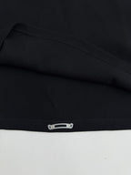 Black long-sleeve shirt cuff with snap-button detail at the hem