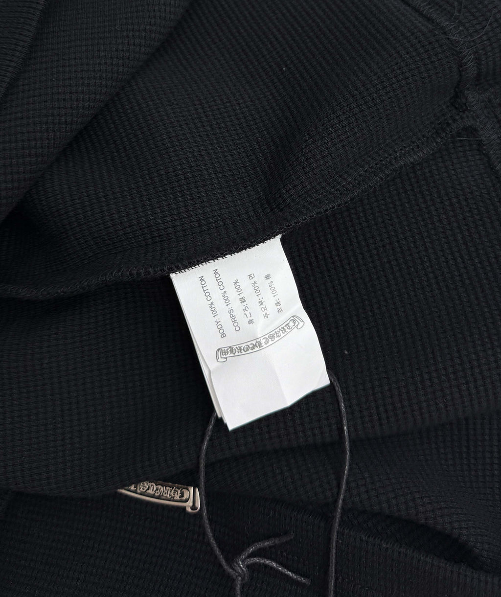 Black long-sleeve shirt inner neck tag visible near the collar seam