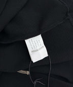 Black long-sleeve shirt inner neck tag visible near the collar seam