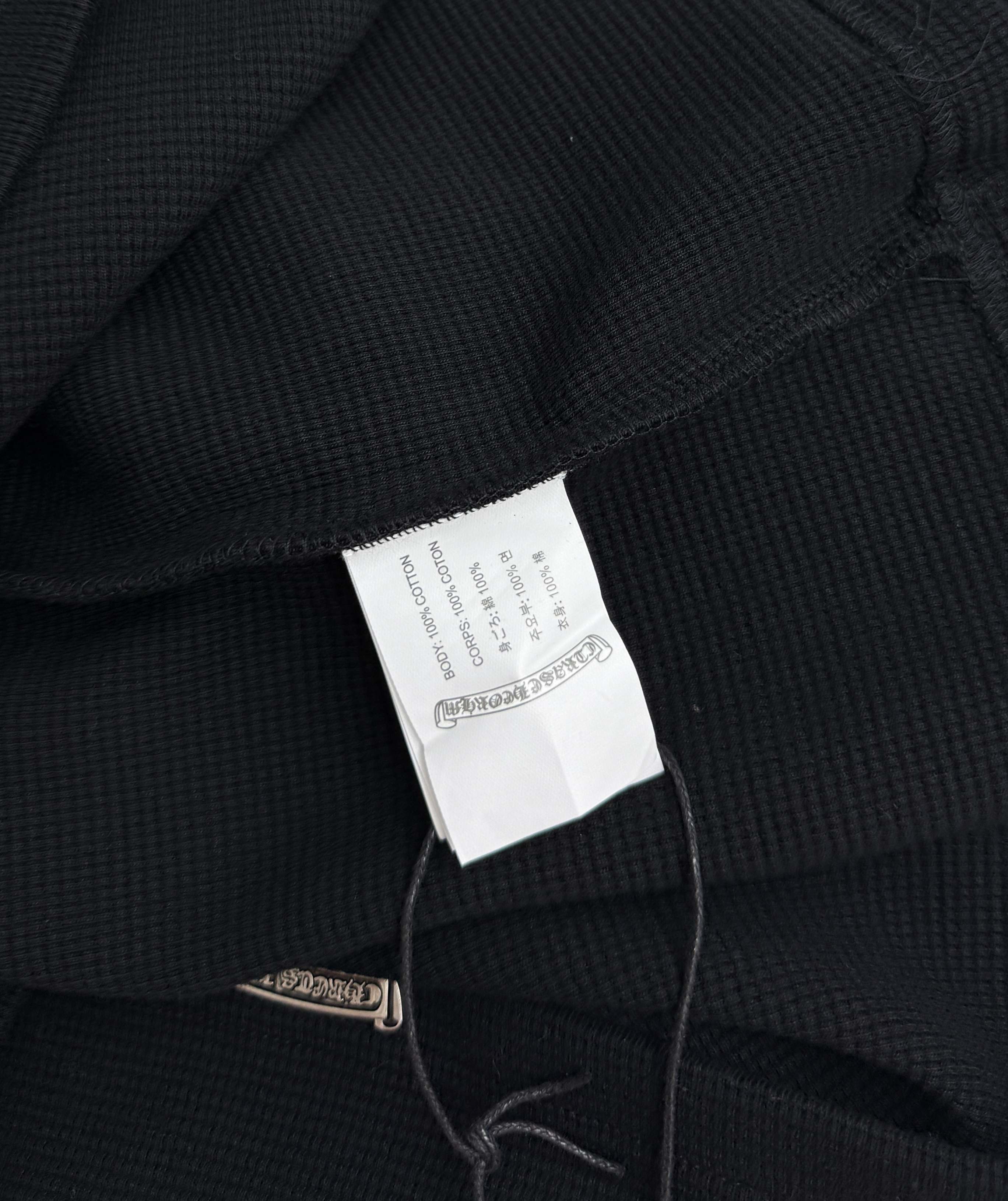 Black long-sleeve shirt inner neck tag visible near the collar seam
