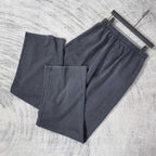 Balenciaga pants set of two in dark navy with elastic waistband and logo patch, angled view