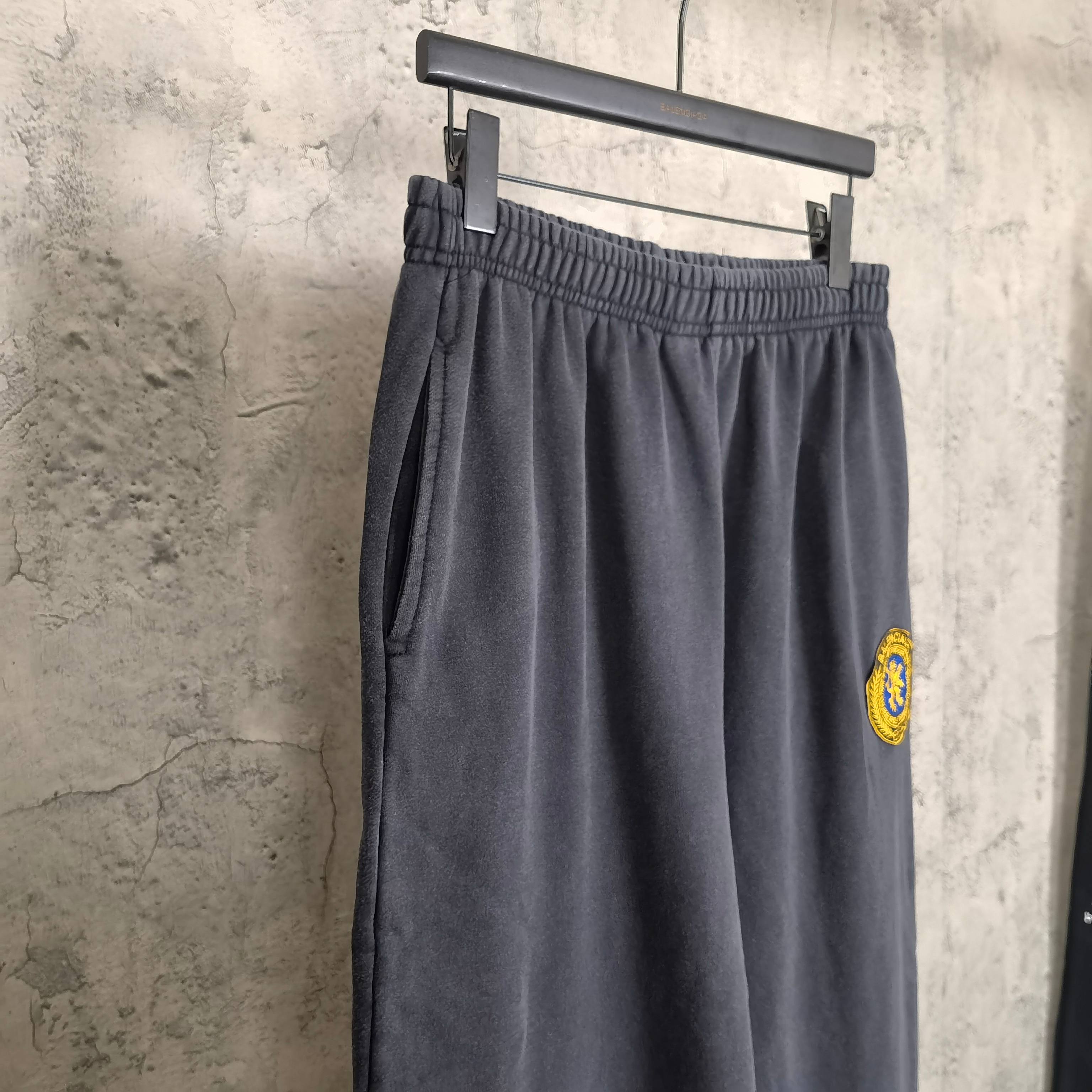 Balenciaga pants in dark navy with elastic waistband, side profile, small logo patch