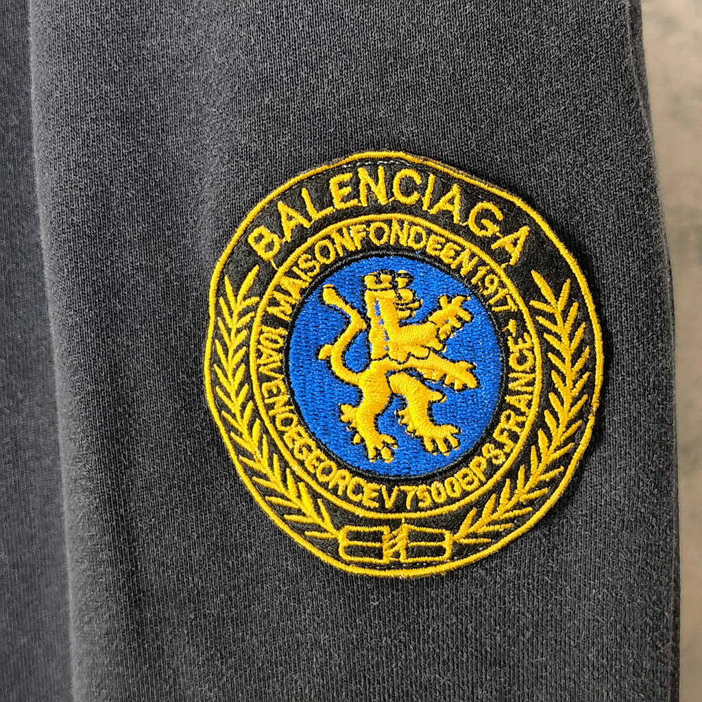 Balenciaga logo patch in yellow and blue on dark navy fabric