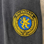 Balenciaga logo patch in yellow and blue on dark navy fabric