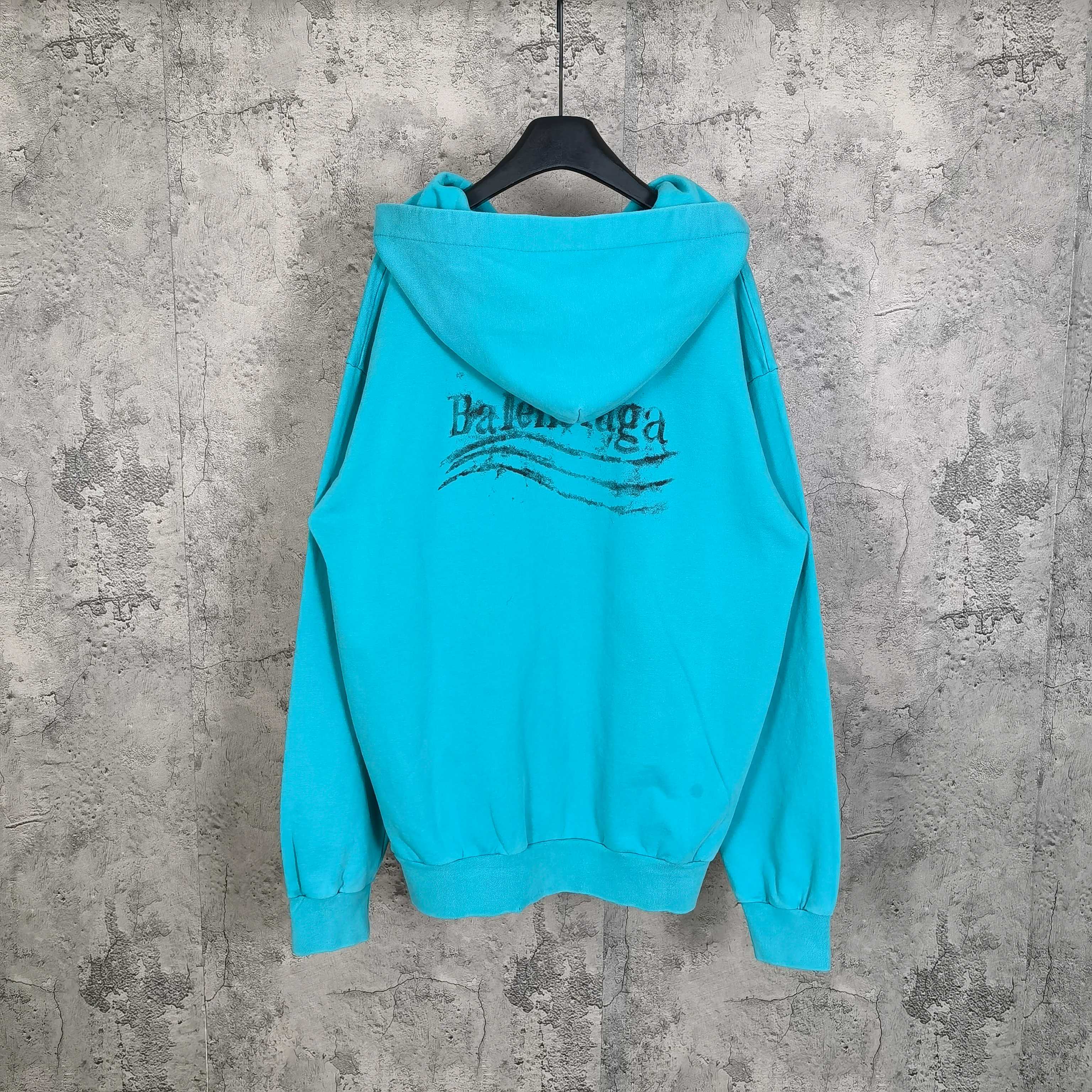 Turquoise zip-up hoodie with hood and Balenciaga logo on back, front pouch pocket