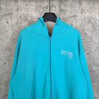 Turquoise zip-up hoodie with hood, full zipper, and Balenciaga logo on chest
