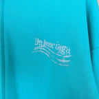 Turquoise hoodie fabric with Balenciaga logo print near center
