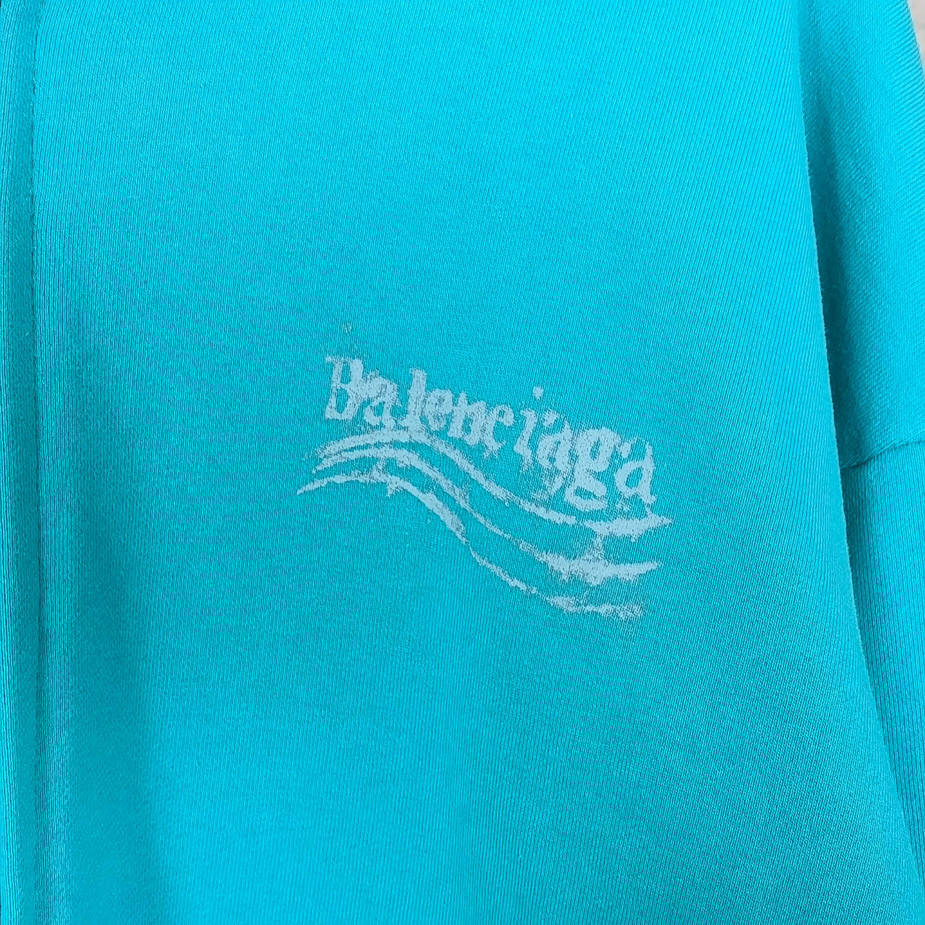 Turquoise hoodie fabric with Balenciaga logo print near center