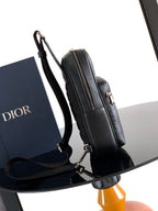 Dior mini backpack bag, black pebbled leather, side view with front zipper and shoulder strap