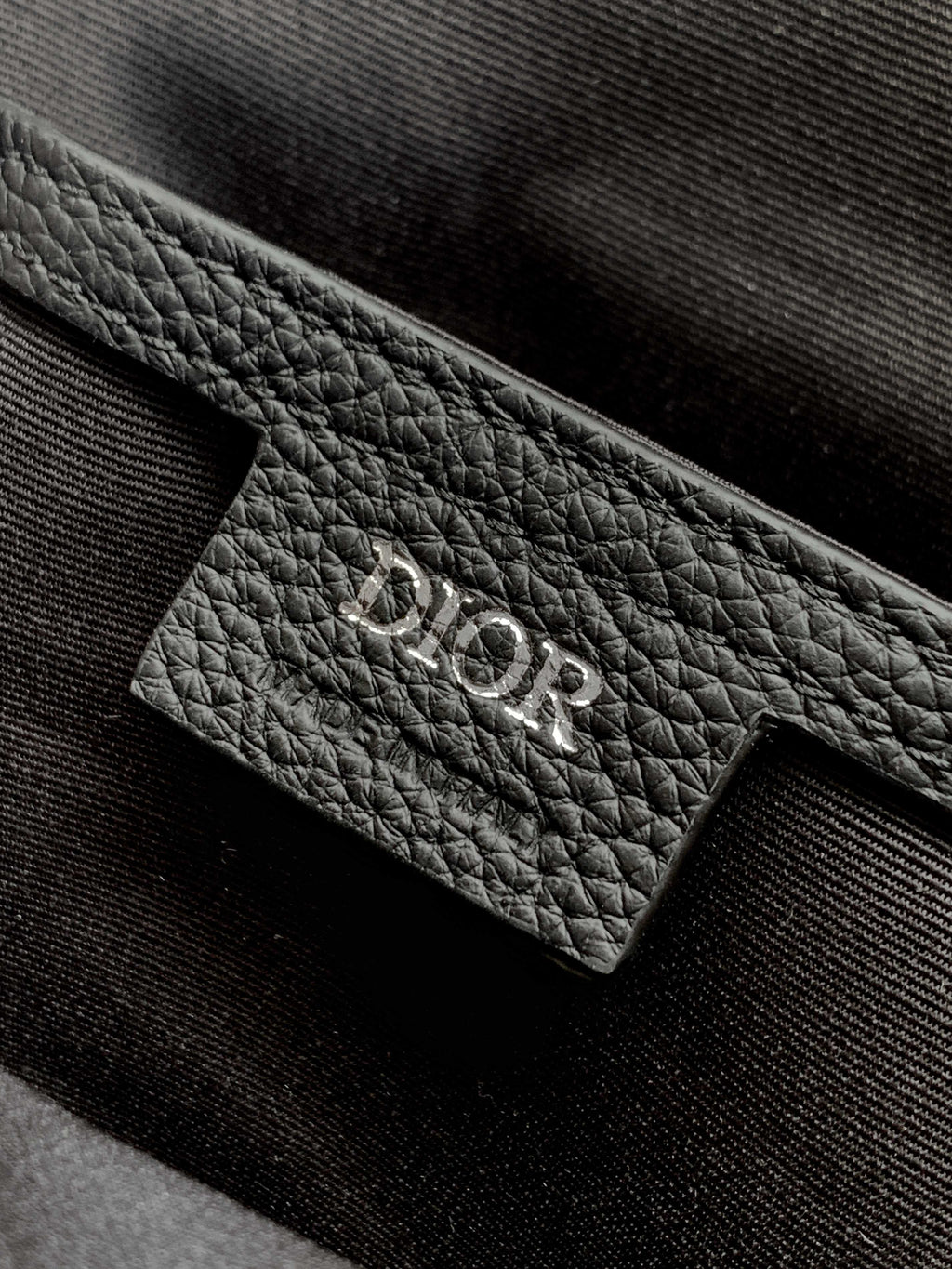 Dior mini bag leather pocket, black textured surface with embossed 'Dior' logo patch