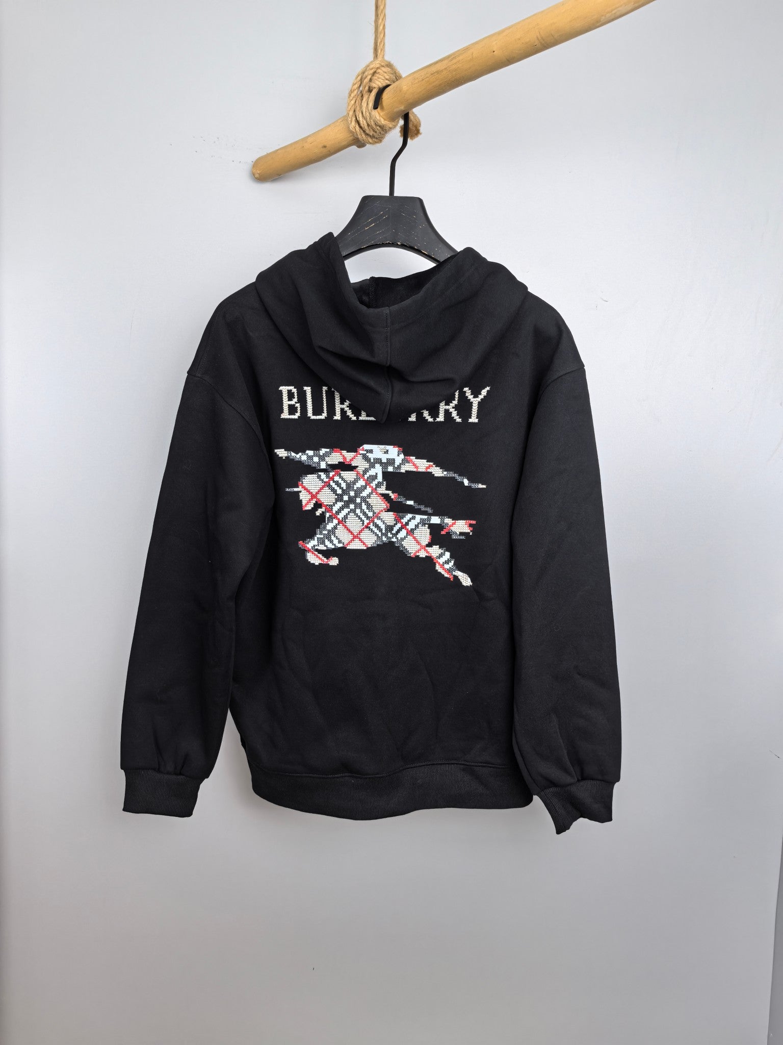 Black pullover hoodie with hood and large Burberry graphic print on the front.