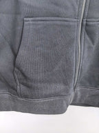 Black hoodie with stitched pocket panel and visible front zipper seam.