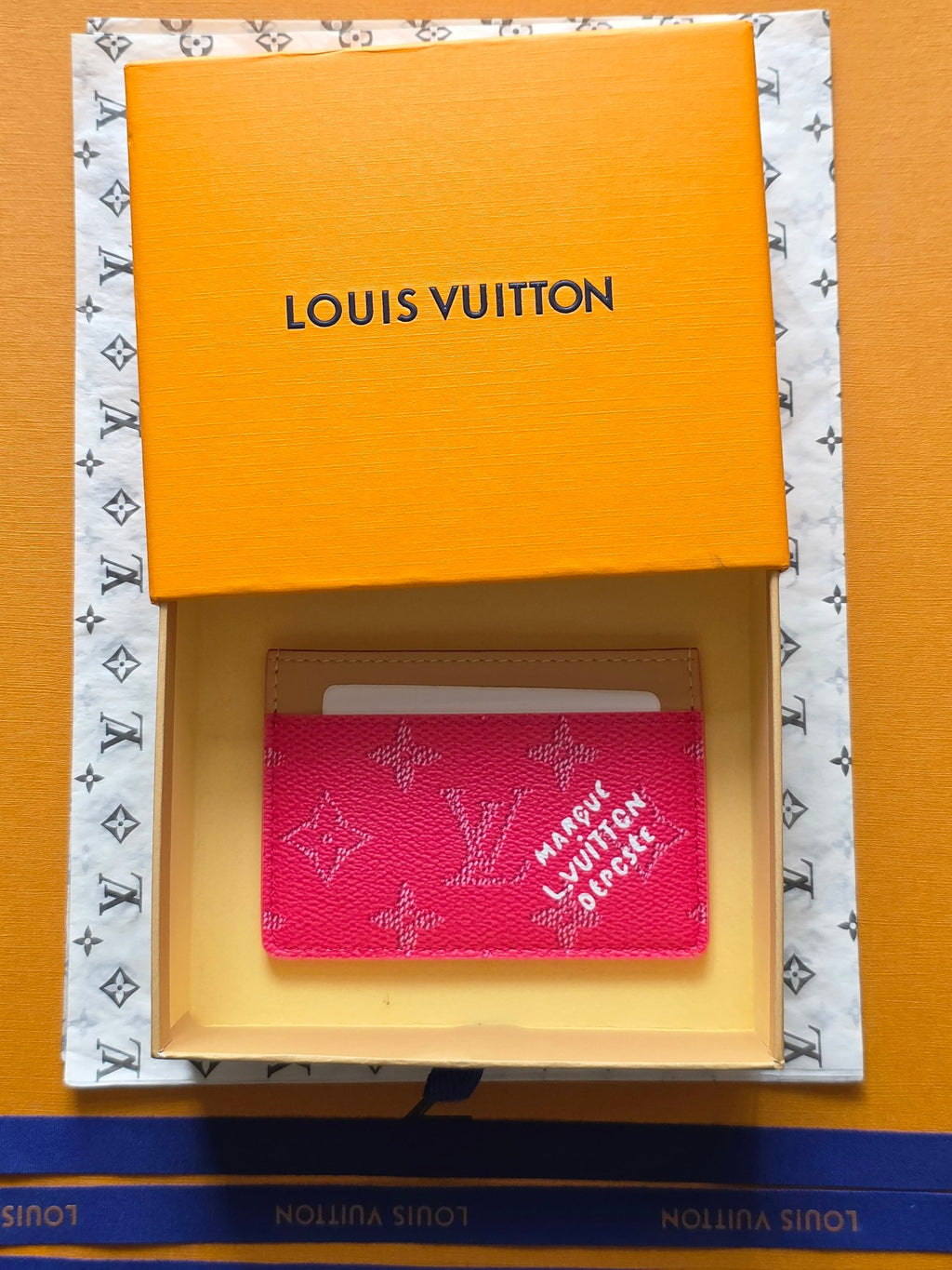 Louis Vuitton small pink monogram card holder with beige border and black “LOUIS VUITTON” logo