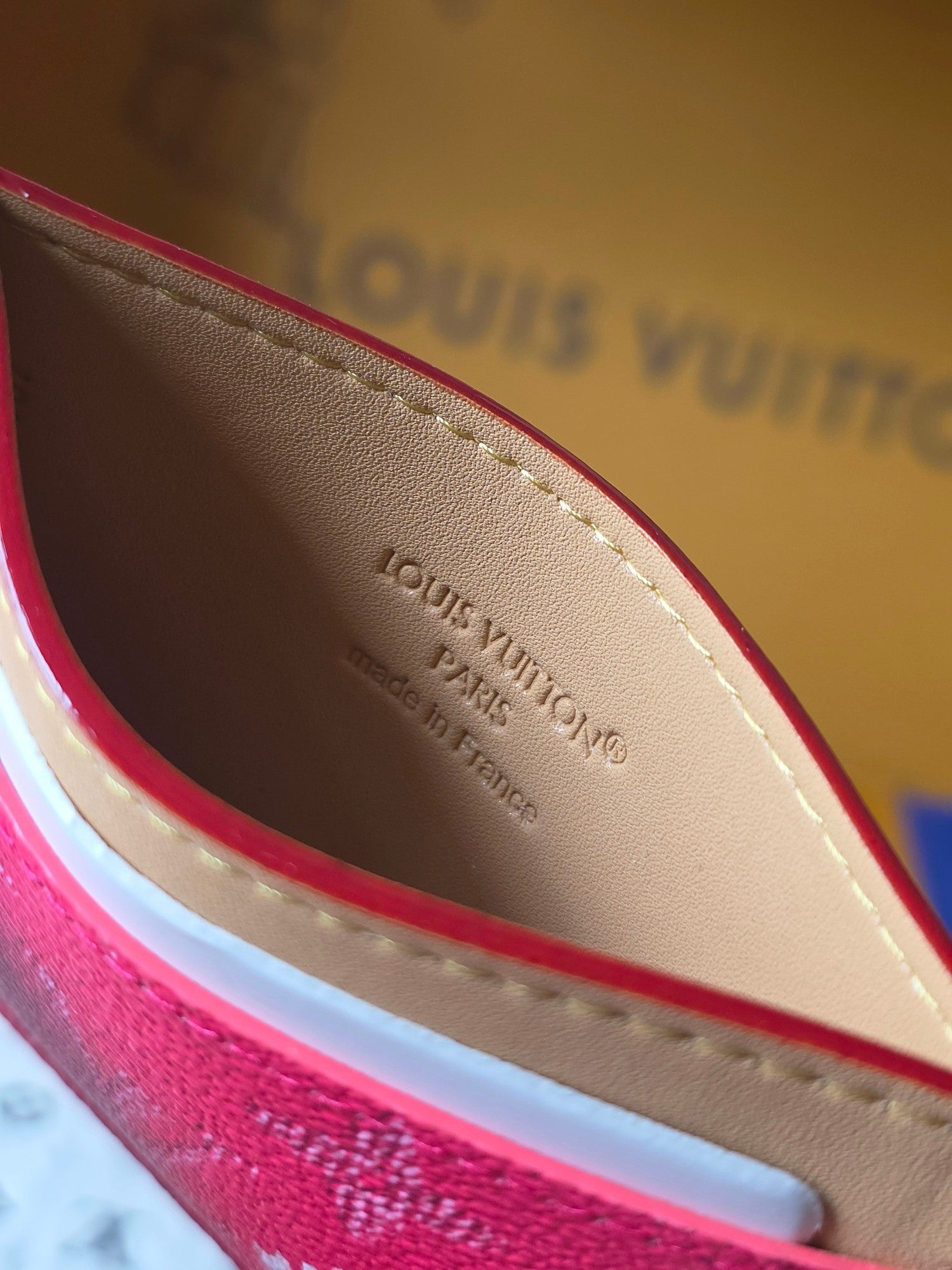 Louis Vuitton small pink monogram card holder interior view with beige lining and embossed text