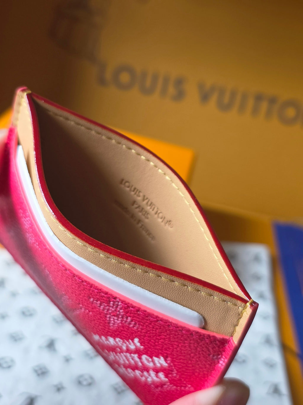 Louis Vuitton small pink monogram card holder interior view with beige lining and red edge