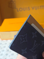 Louis Vuitton card case side view, blue monogram with tan interior