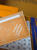 Small tan Louis Vuitton monogram bag front panel with embossed blue logo
