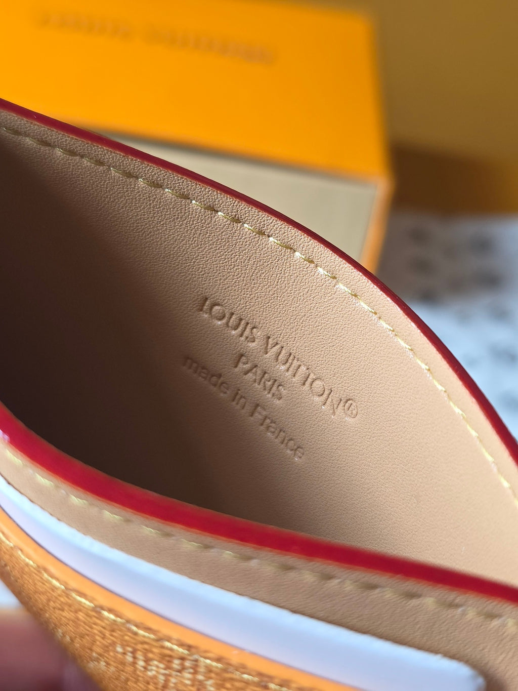 Louis Vuitton monogram card holder interior close-up with embossed brand text