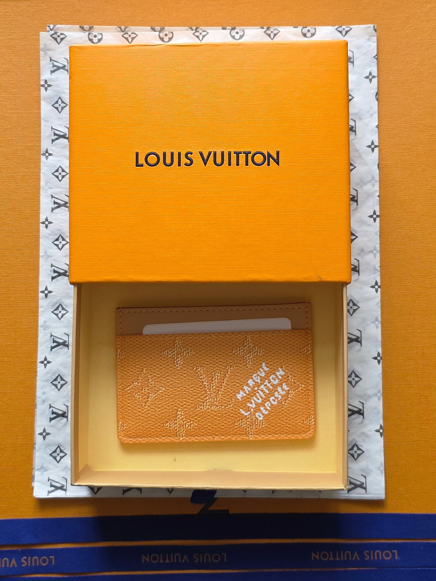 Louis Vuitton monogram card holder in tan leather inside orange gift box