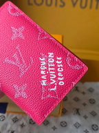 Pink monogram card holder corner close-up with logo print