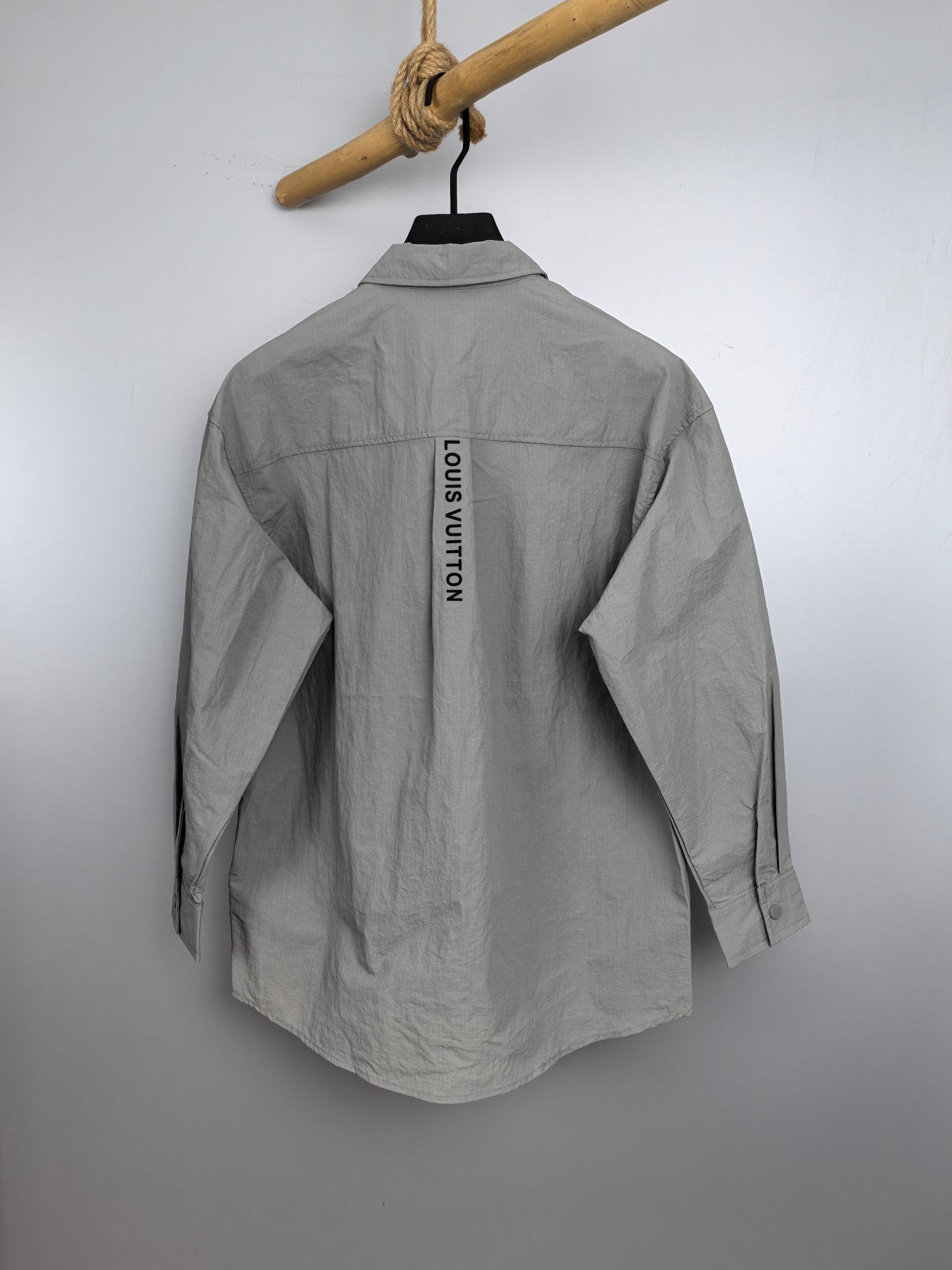 Light gray jacket back with vertical "LOUIS VUITTON" lettering