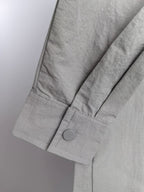 Gray jacket sleeve with buttoned cuff and structured seam detail